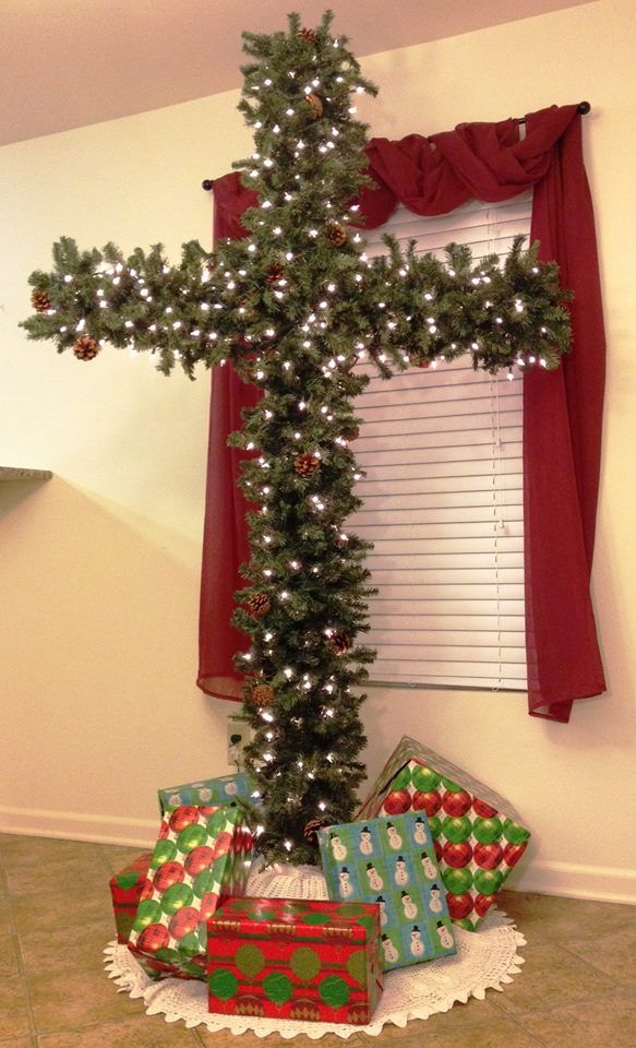 a christmas tree with presents under it in front of a window decorated for the holiday season