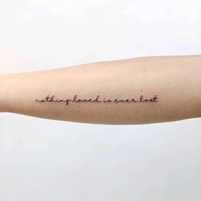 a person with a tattoo on their arm that says, nothing happened is ever lost