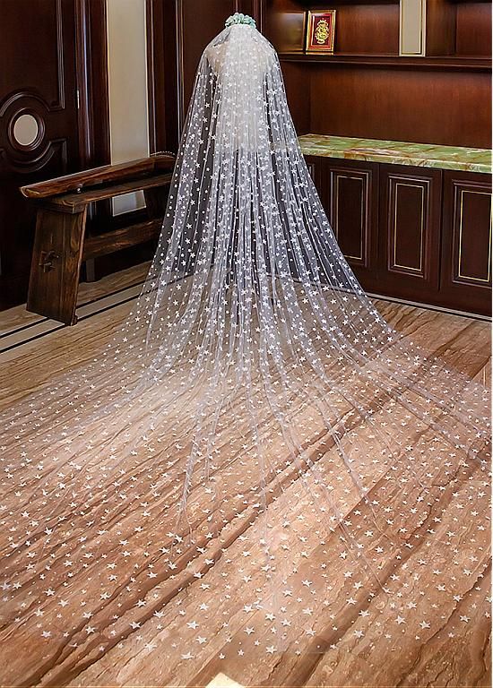 a wedding veil with stars on it sits in the middle of a room next to a bench