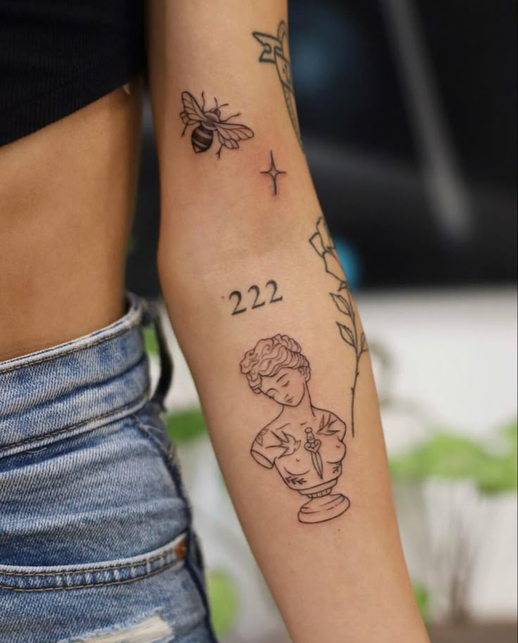 a woman's arm with a tattoo on it that reads 22 and has a bee flying over her shoulder