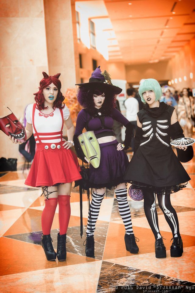 three women dressed up in halloween costumes walking down the hall with their hands on their hipss