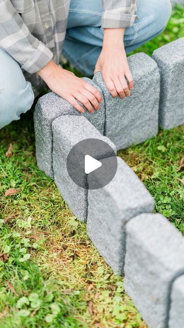 a person kneeling down next to some bricks