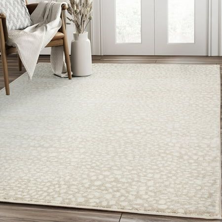 a living room with a white rug on the floor and a chair next to it