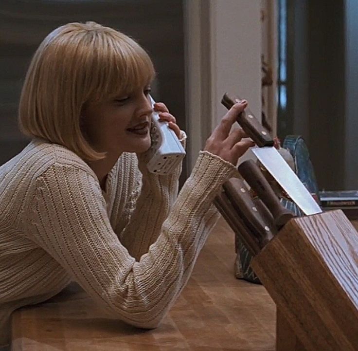 a woman sitting at a counter talking on a cell phone