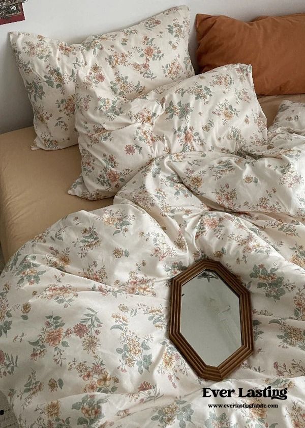 an unmade bed with pillows and a mirror on the headboard next to it