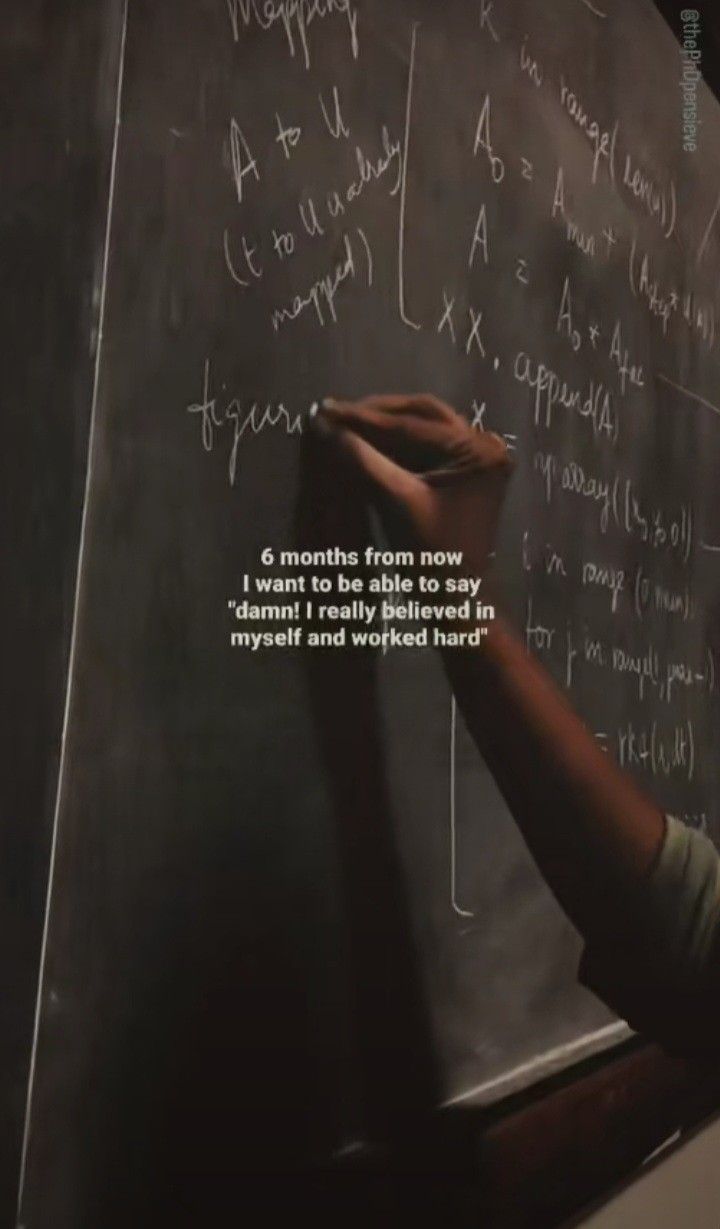 a person writing on a blackboard in front of a chalk board with writing on it