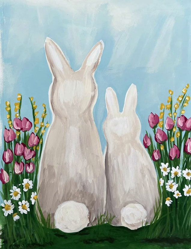 two white rabbits sitting in the grass with flowers