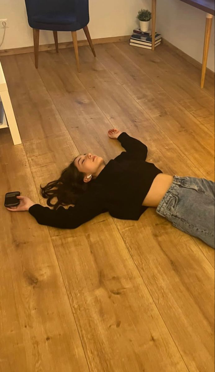 a woman laying on the floor with her cell phone