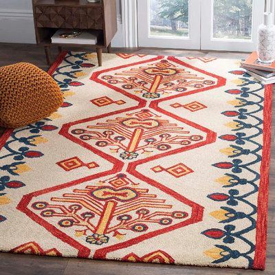 a colorful rug with an intricate design on the floor next to a chair and window