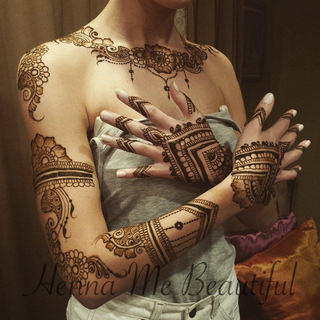 a woman with henna tattoos on her arm and hand is posing for the camera