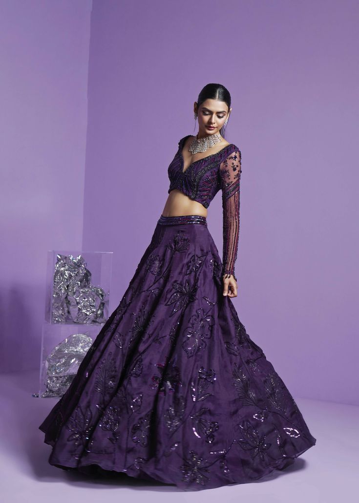 Purple lehenga with a deep neck long-sleeved embroidered blouse paired with a-line floral embroidered lehenga and mesh dupatta. Purple Lehenga, Modern Bridal Gowns, Indian Wedding Bride, Full Sleeve Blouse, Organza Lehenga, Indian Bridal Lehenga, Vacuum Storage, Embroidered Lehenga, Lehenga Blouse