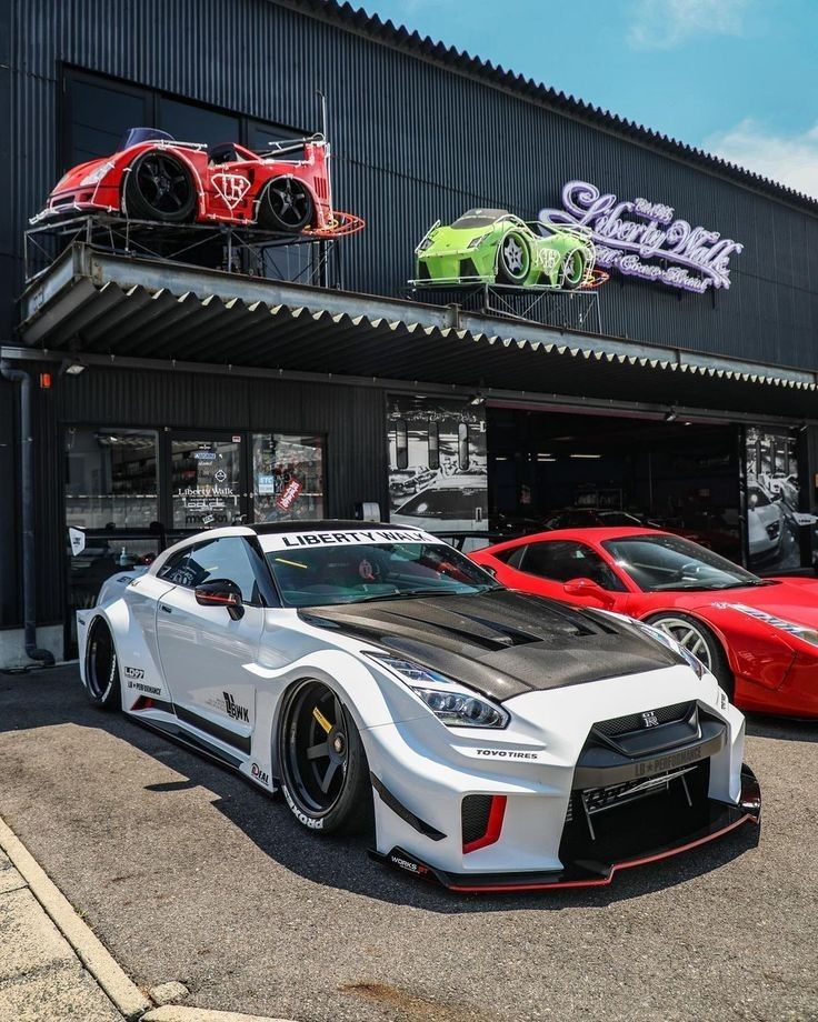 three sports cars parked in front of a building