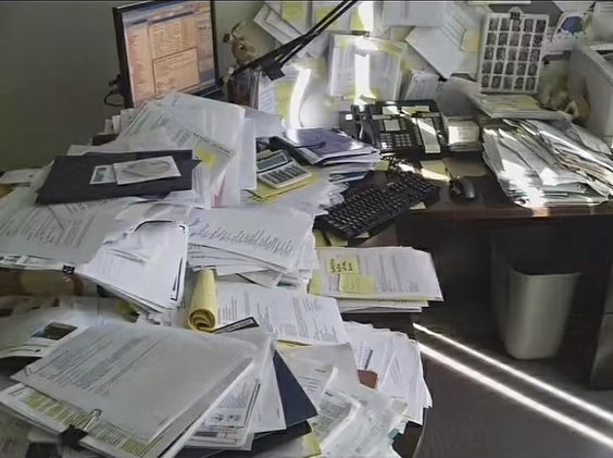 an office desk full of papers and paperwork