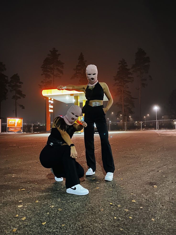 two people with masks on standing in the street