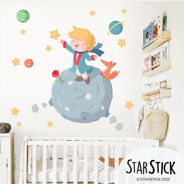 a child's bedroom with a wall sticker depicting a boy on top of a rock