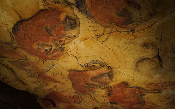 an artistic painting on the side of a cave wall with animals and birds painted on it