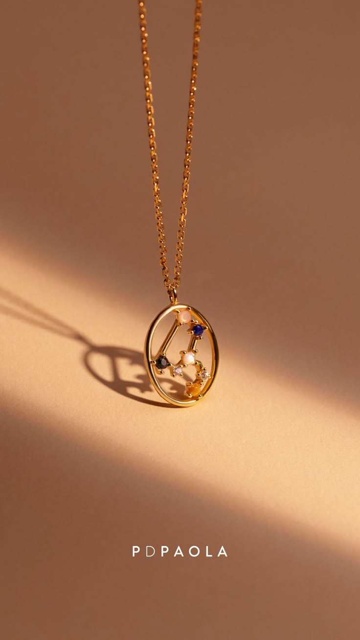 a gold necklace with an astrological symbol on it