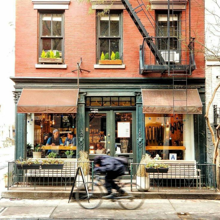 a person riding a bike past a store front