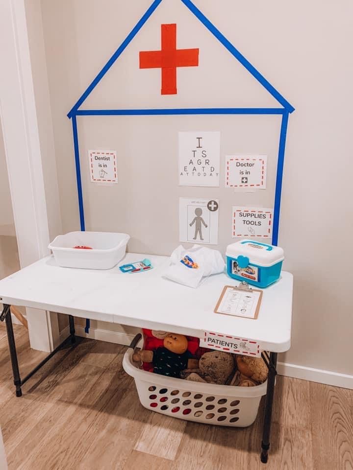 a white table topped with lots of food next to a red and blue cross on the wall