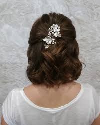 the back of a woman's head wearing a hair comb with flowers on it