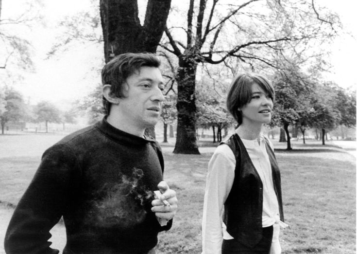 the man and woman are walking together in the park