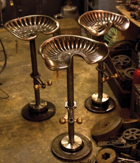 three metal stools sitting next to each other on top of a floor in a room