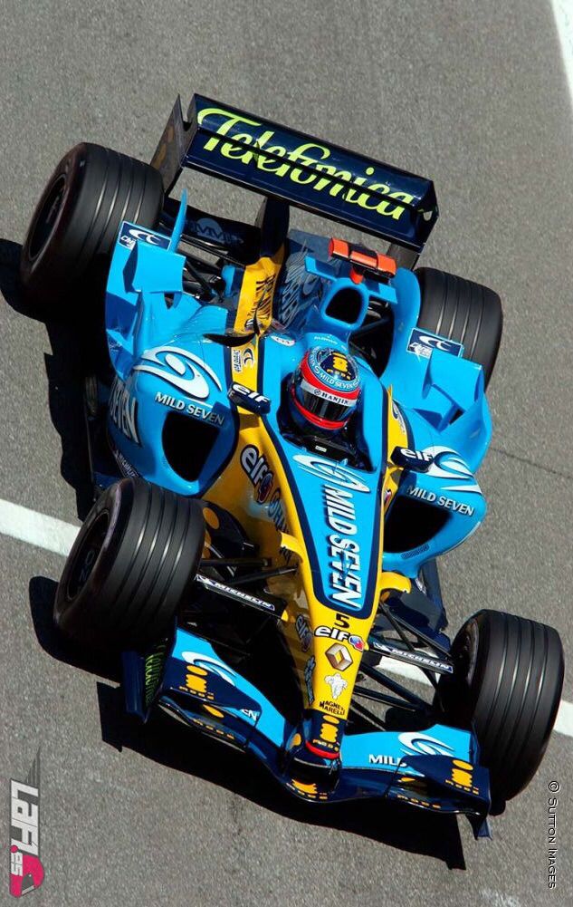 a man driving a blue and yellow race car