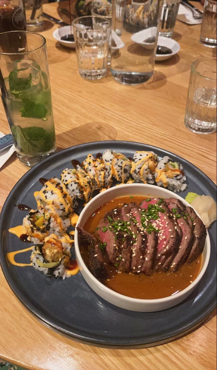 a plate that has some kind of food on it with chopsticks and sauce