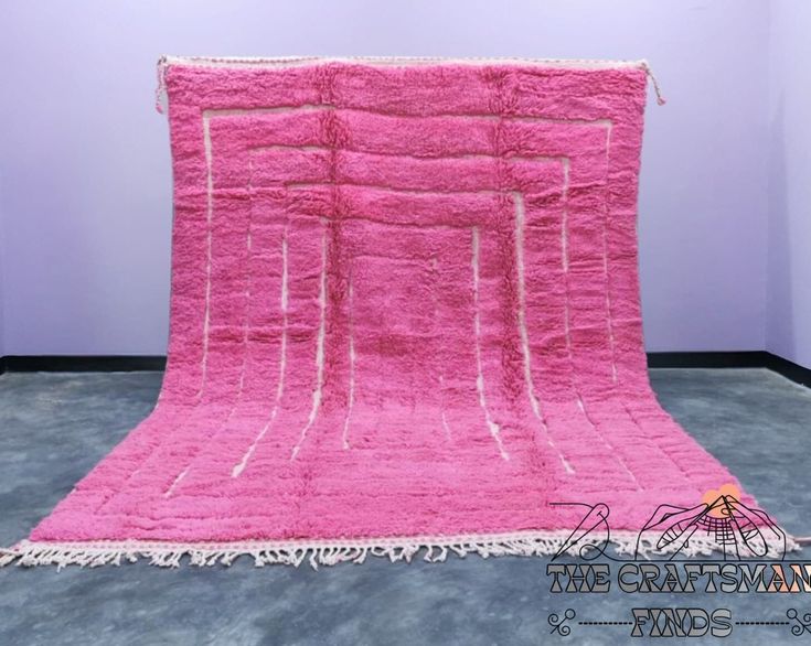 a pink rug with fringes on the floor in front of a white wall and purple walls