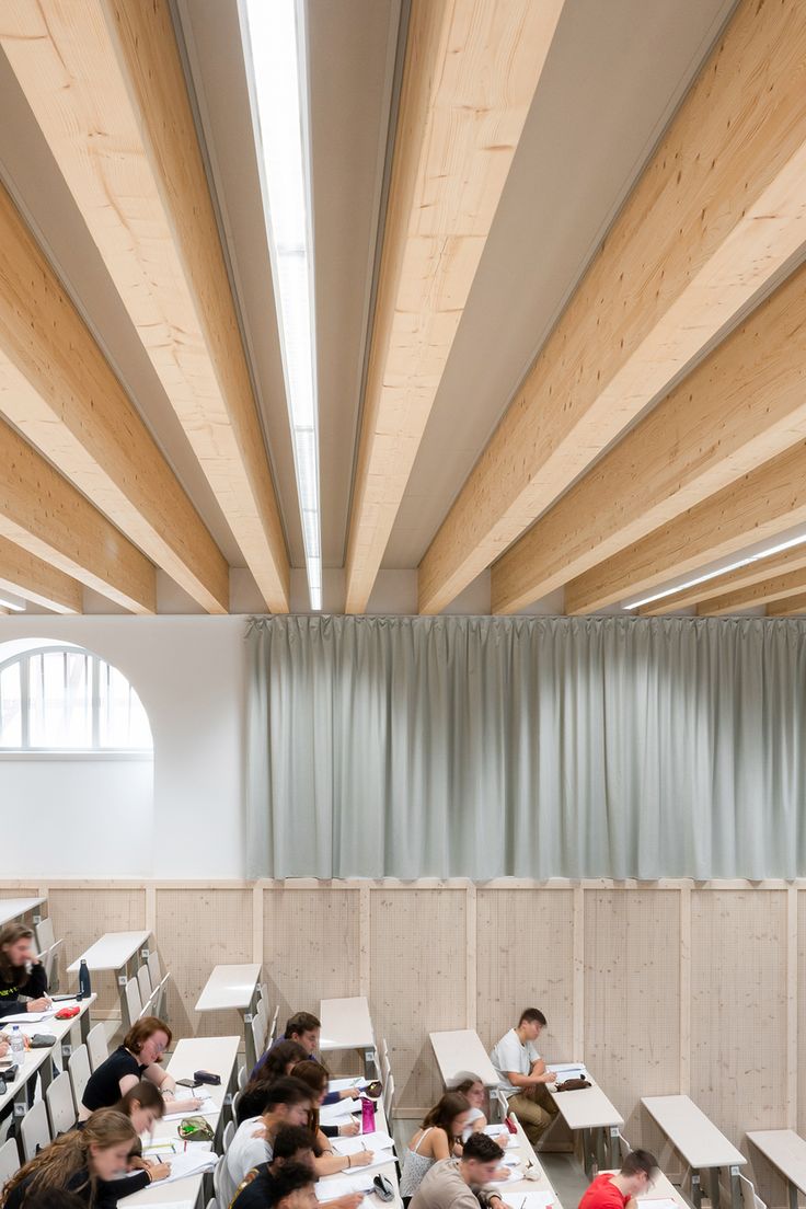 A university lecture hall that is located inside of a heritage building and has exposed wood beam ceilings Modern Lecture Hall, University Classroom Design, Lecture Hall, Lectures Hall, Adaptive Reuse, Classroom Design, Ceiling Tiles, Color Effect, Strasbourg