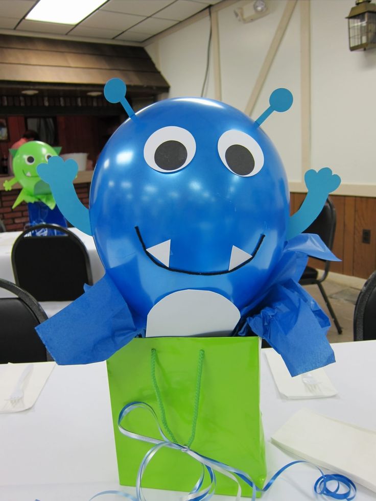 a blue balloon sitting on top of a table next to a green bag with eyes