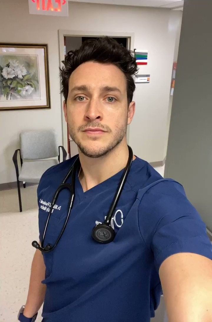 a man with a stethoscope is taking a selfie in the hospital