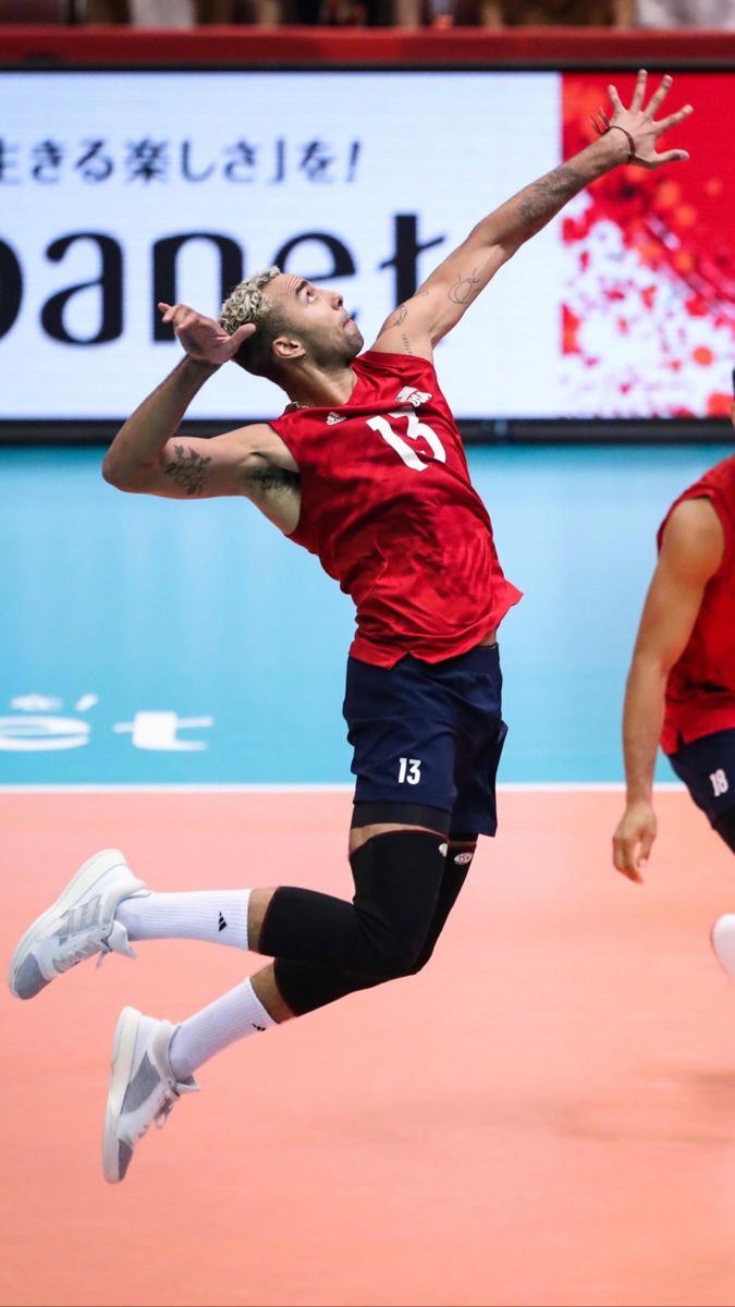 a man jumping in the air to hit a tennis ball