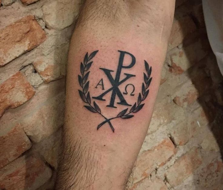 a man's arm with a tattoo on it that has the letter k and is surrounded by laurels