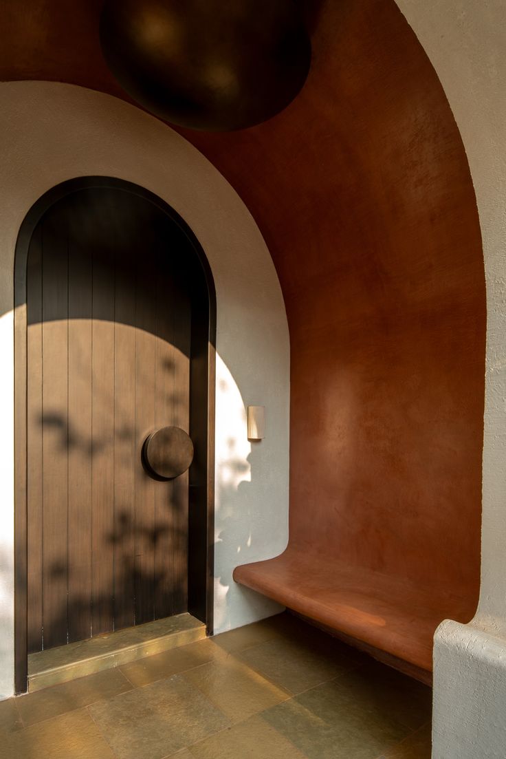 an arched doorway with a bench in front of it