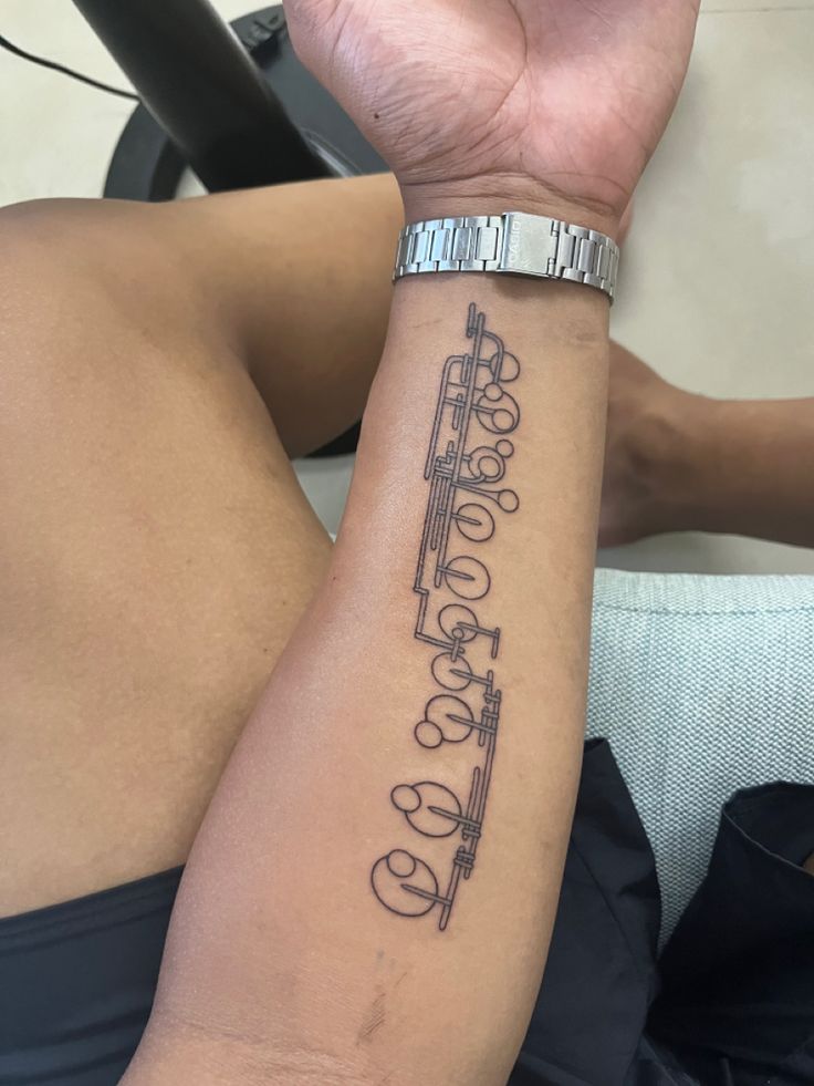 a person with a tattoo on their arm holding up the word love in cursive writing