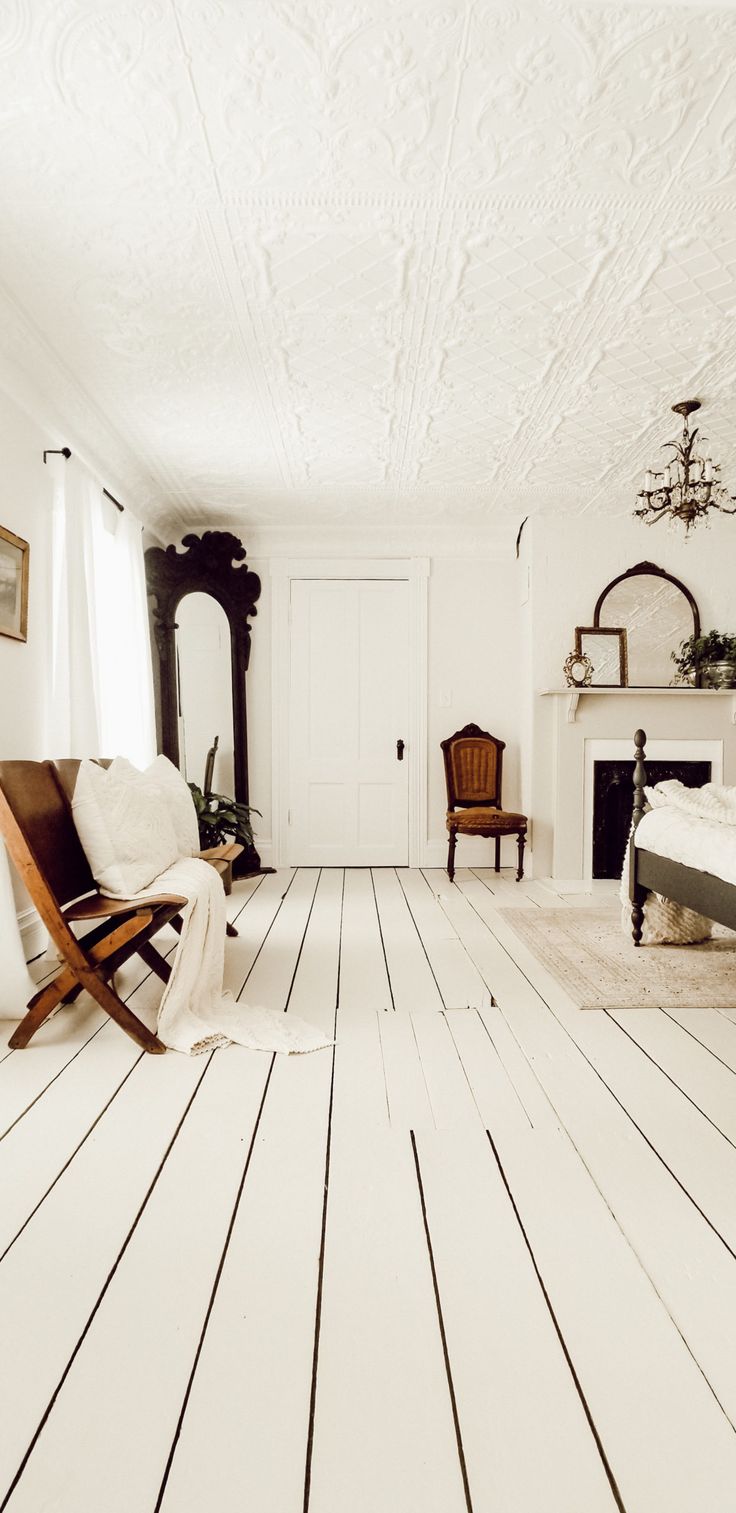 a bedroom with white walls and wood floors