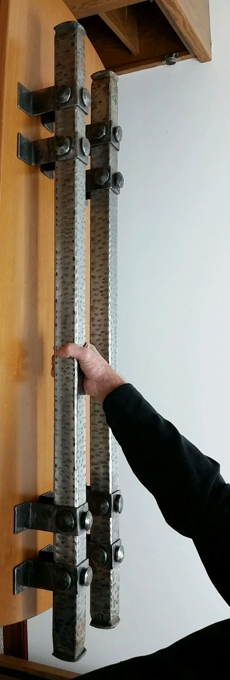 a person is pointing at a metal object on the wall