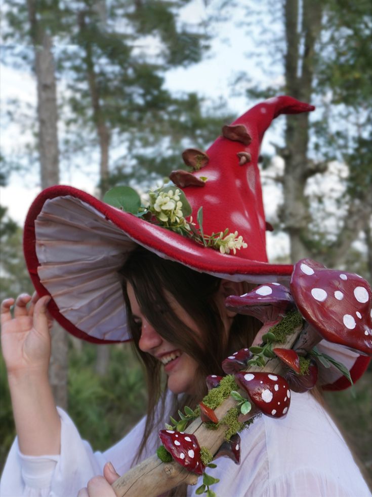 a woman wearing a red hat with mushrooms on it