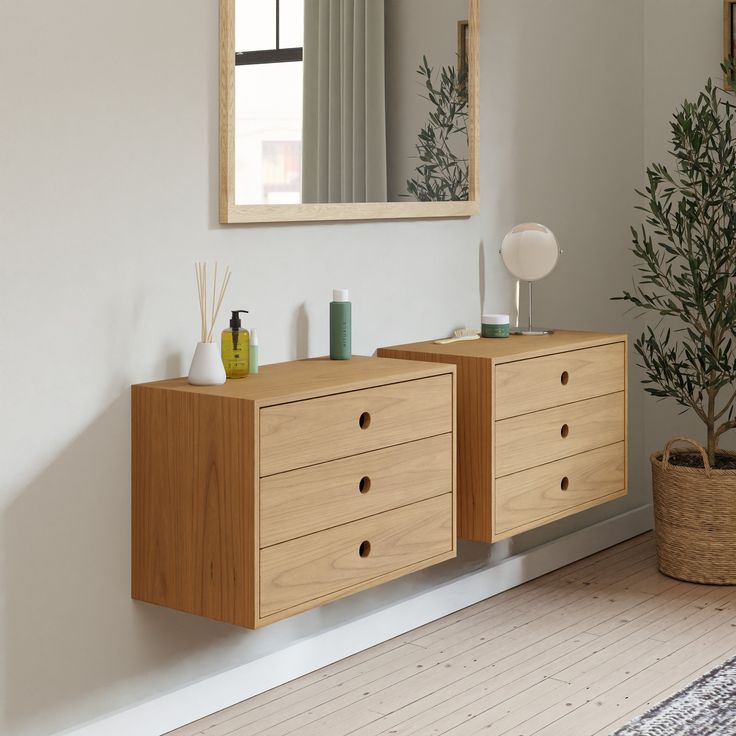 a wooden dresser sitting in front of a mirror on top of a wall next to a potted plant