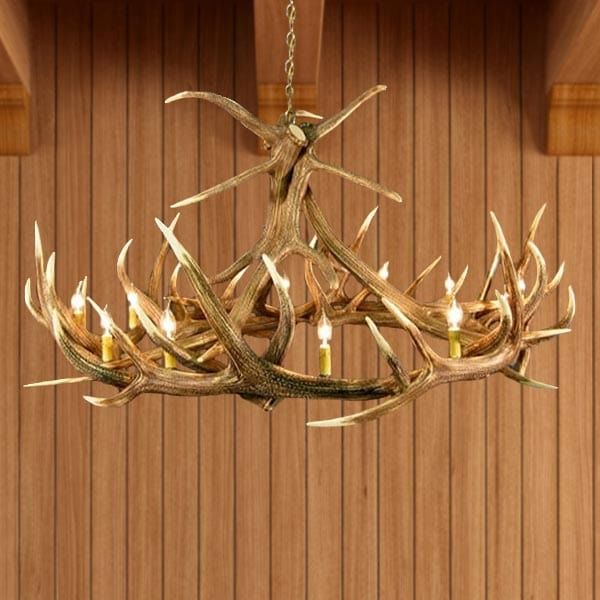 a deer antler chandelier hanging from a wooden ceiling with candles in it