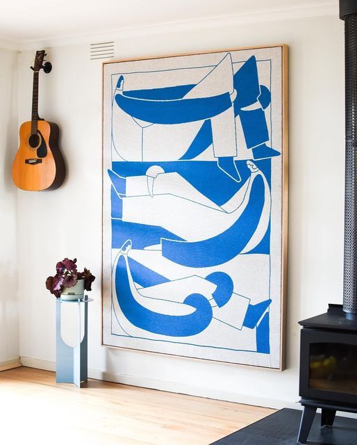 a blue and white painting hanging on the wall