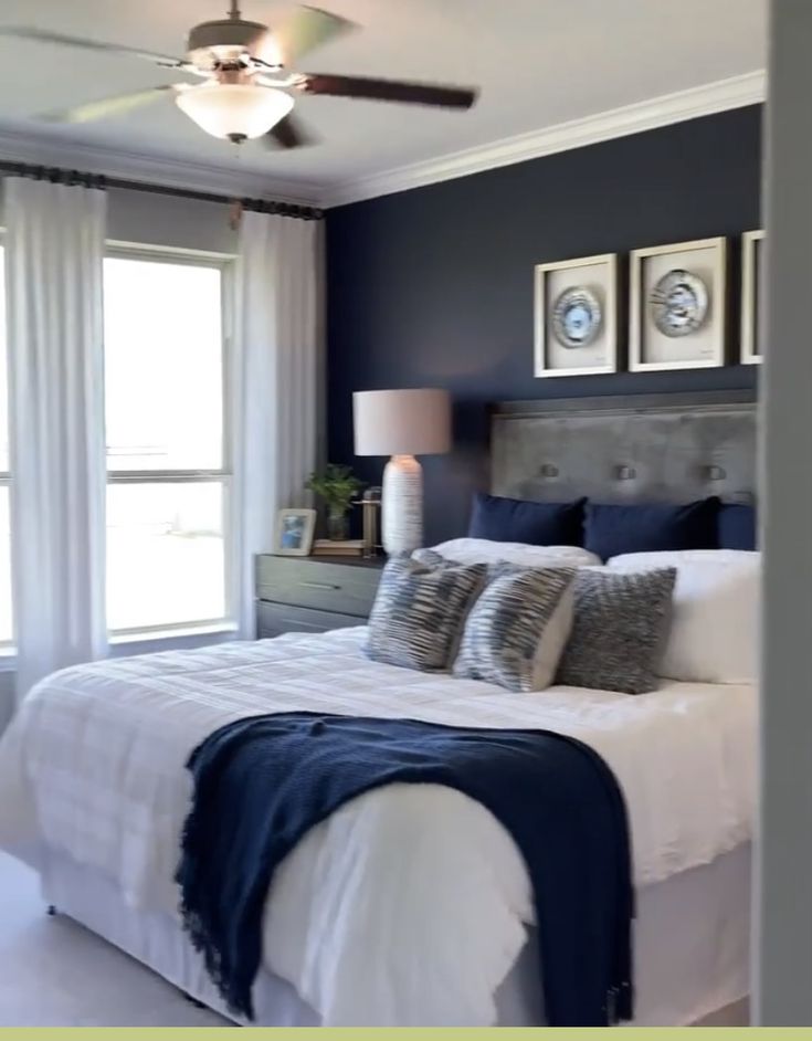 a bedroom with blue walls and white bedding