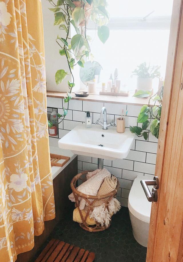 a bathroom with a toilet, sink and shower curtain in it's window sill