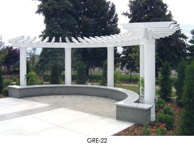 a large white pergoline sitting on top of a cement slab next to trees