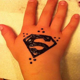 a hand with a superman symbol tattoo on it