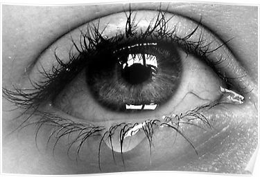 an eye is shown with long eyelashes and black ink on the bottom half of it