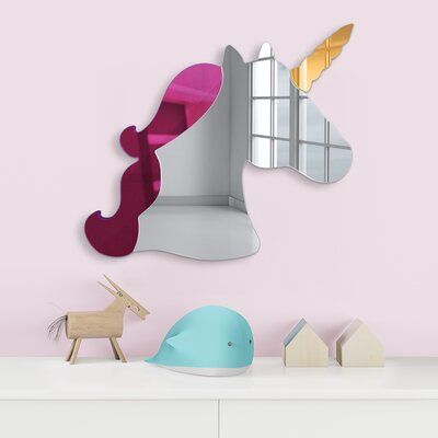 there is a mirror on the wall and a toy horse next to it in front of a pink wall