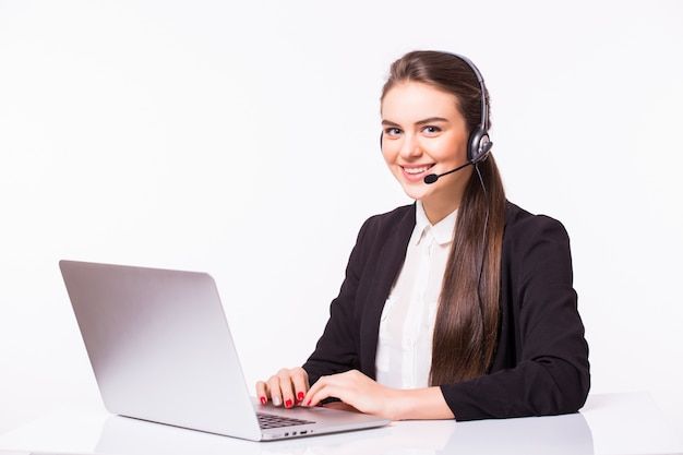 a woman sitting at a desk with a laptop computer and headphones on her ears