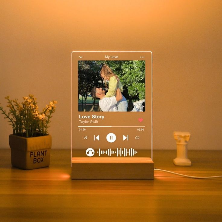 an mp3 player sitting on top of a wooden table next to a potted plant